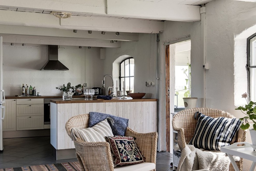 Vintage kitchen in Other with beaded cabinets, white cabinets and a breakfast bar.