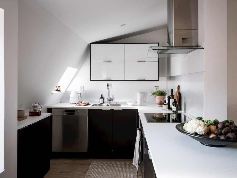 Design ideas for a scandinavian u-shaped kitchen in Gothenburg with a submerged sink, flat-panel cabinets, black cabinets, stainless steel appliances, medium hardwood flooring, brown floors and white worktops.