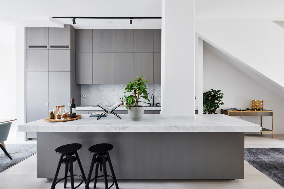Exempel på ett minimalistiskt grå linjärt grått kök med öppen planlösning, med en undermonterad diskho, släta luckor, grå skåp, grått stänkskydd, en köksö och beiget golv