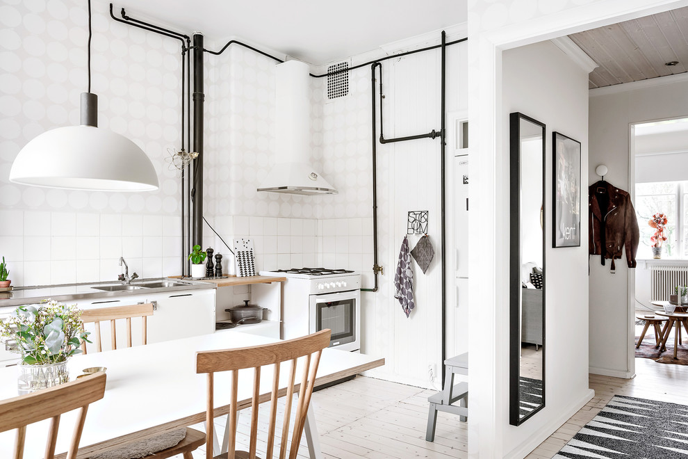 Immagine di una cucina abitabile scandinava di medie dimensioni con ante lisce, ante bianche, parquet chiaro, nessuna isola e pavimento beige