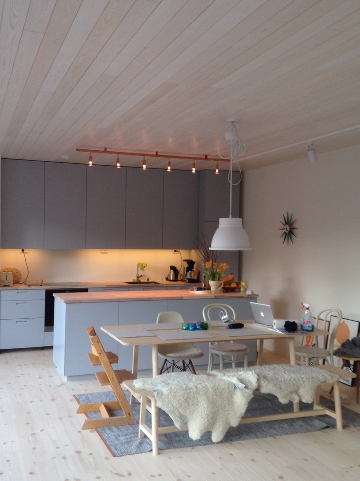 Idéer för minimalistiska kök och matrum, med träbänkskiva, ljust trägolv och en köksö