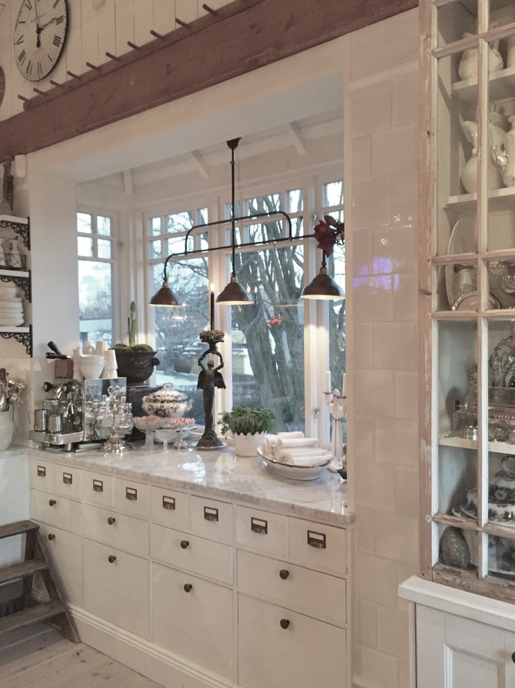 Immagine di una grande cucina vittoriana con lavello stile country, ante grigie, top in marmo, paraspruzzi in gres porcellanato e elettrodomestici in acciaio inossidabile