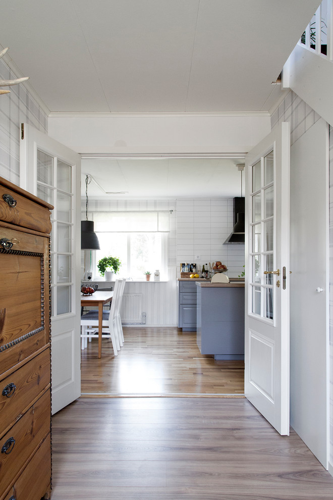Bild på ett mellanstort lantligt kök och matrum, med en dubbel diskho, grå skåp, laminatbänkskiva, mellanmörkt trägolv och en köksö