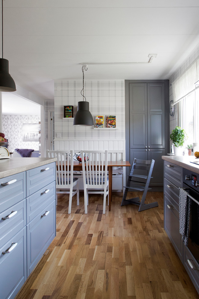 Foto på ett mellanstort lantligt kök och matrum, med en dubbel diskho, grå skåp, laminatbänkskiva, mellanmörkt trägolv och en köksö