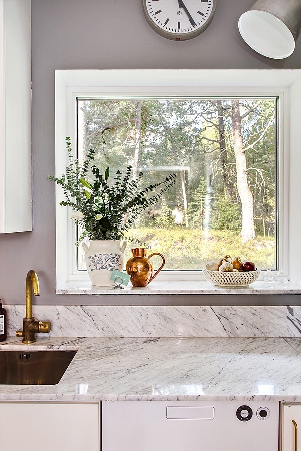 Foto på ett avskilt, mellanstort skandinaviskt kök, med en nedsänkt diskho, släta luckor, vita skåp, marmorbänkskiva, vitt stänkskydd och stänkskydd i marmor