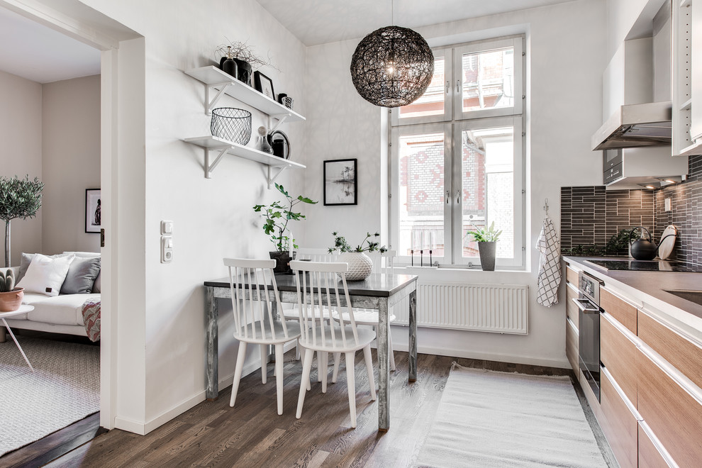 Einzeilige, Mittelgroße Skandinavische Küche mit flächenbündigen Schrankfronten, hellen Holzschränken, Küchenrückwand in Braun, Rückwand aus Stäbchenfliesen und braunem Boden in Göteborg
