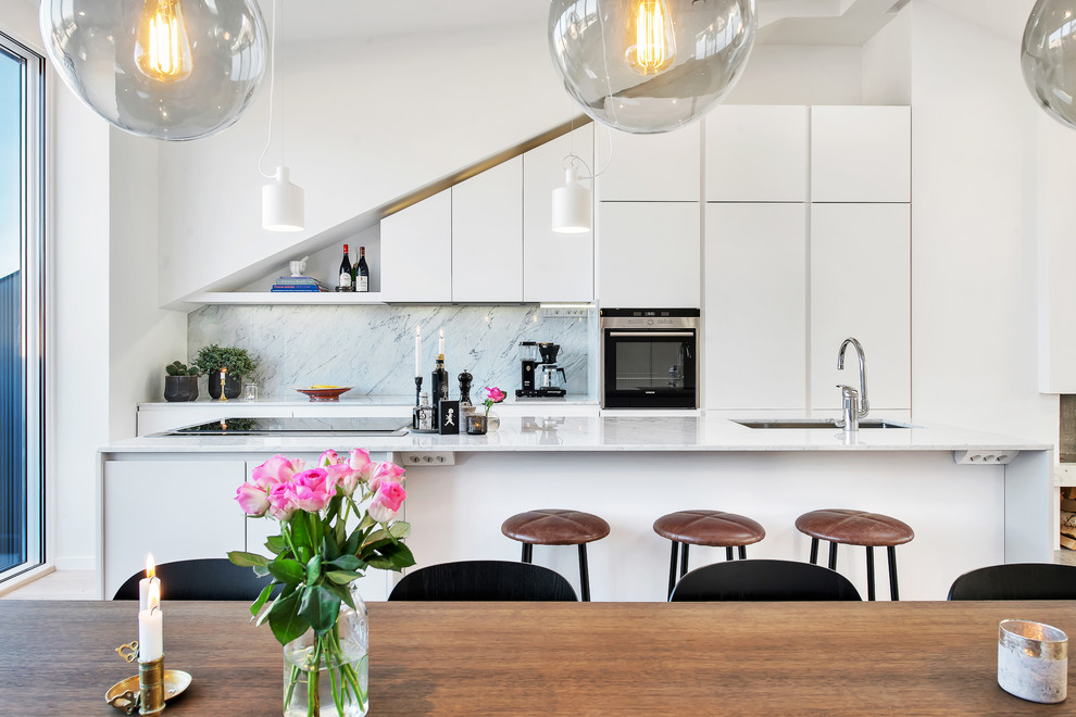 Zweizeilige, Mittelgroße Moderne Wohnküche mit Unterbauwaschbecken, flächenbündigen Schrankfronten, weißen Schränken, Küchenrückwand in Grau, Kücheninsel und Marmor-Arbeitsplatte in Stockholm