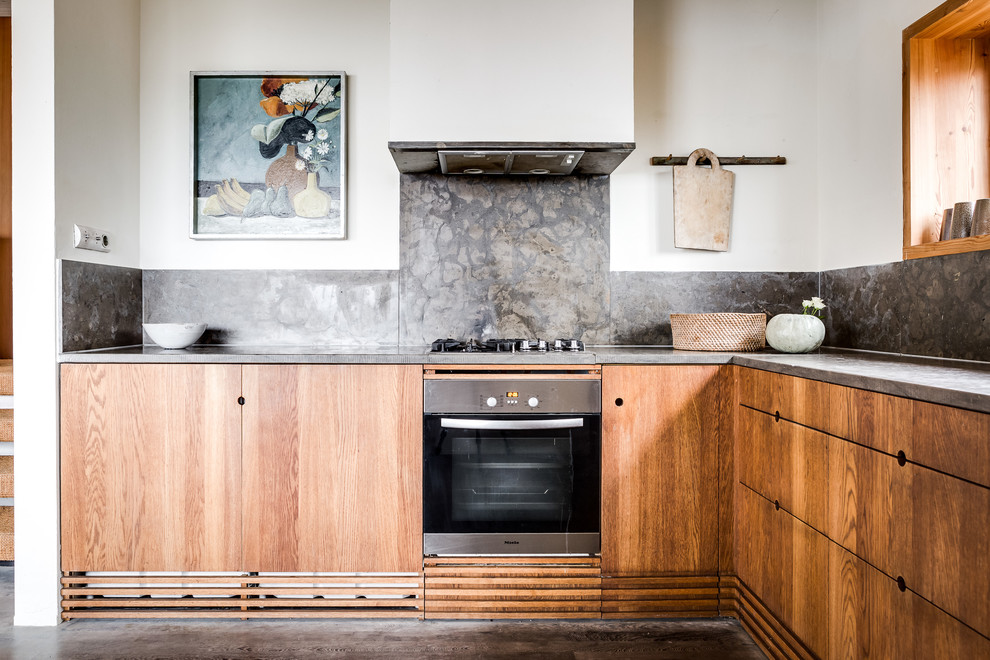 Example of a small danish l-shaped kitchen design in Stockholm with flat-panel cabinets, medium tone wood cabinets, gray backsplash and stone slab backsplash