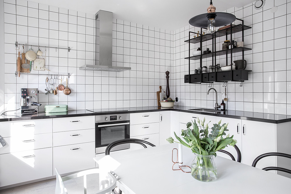 Inspiration för mellanstora skandinaviska l-kök, med en enkel diskho, släta luckor, vita skåp, granitbänkskiva och rostfria vitvaror
