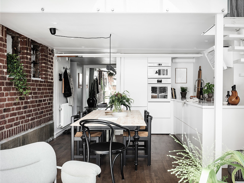Свежая идея для дизайна: угловая кухня-гостиная в скандинавском стиле с плоскими фасадами, белыми фасадами, белой техникой, темным паркетным полом, коричневым полом и белой столешницей без острова - отличное фото интерьера