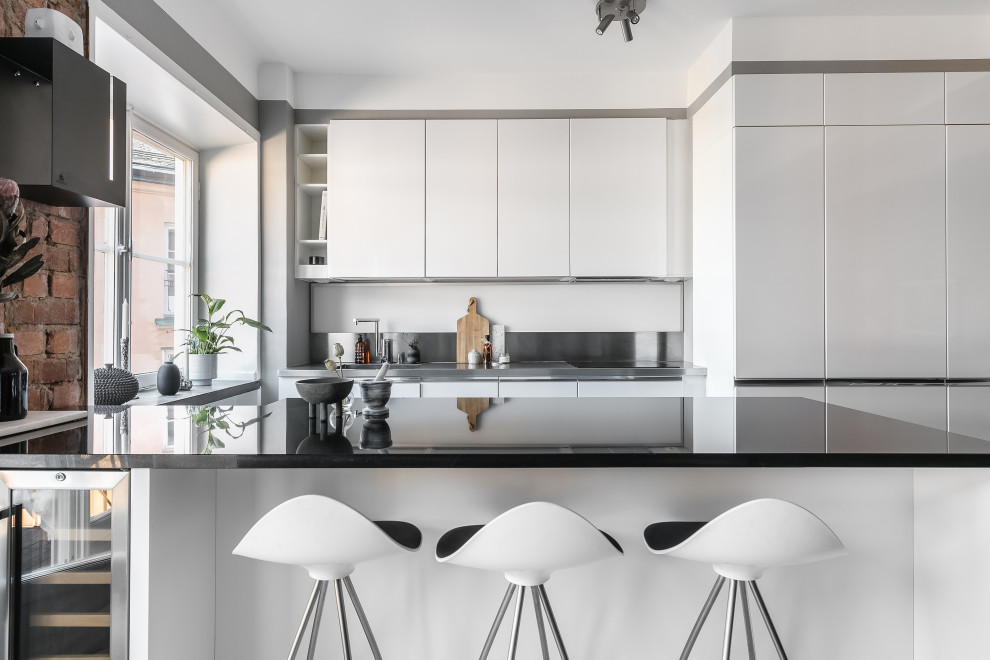 Idéer för att renovera ett skandinaviskt u-kök, med en integrerad diskho, släta luckor, vita skåp, bänkskiva i rostfritt stål, stänkskydd med metallisk yta och en halv köksö