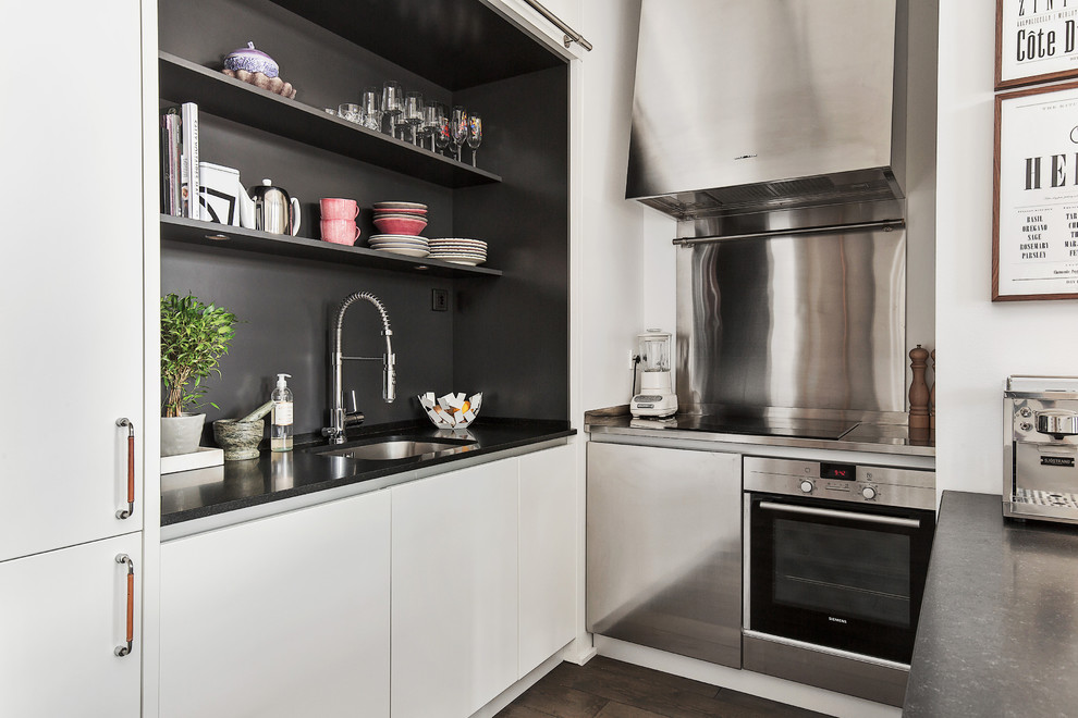 Inspiration för ett mellanstort skandinaviskt u-kök, med en undermonterad diskho, släta luckor, vita skåp, rostfria vitvaror, mörkt trägolv, en halv köksö och granitbänkskiva