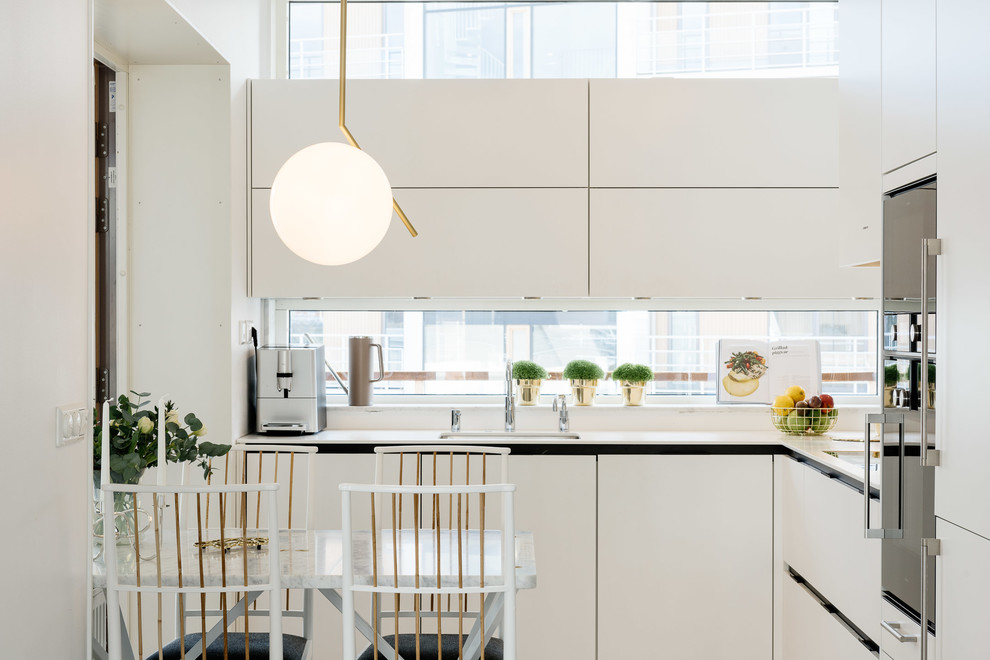 Mittelgroße Moderne Wohnküche ohne Insel in L-Form mit Unterbauwaschbecken, flächenbündigen Schrankfronten, weißen Schränken und Küchengeräten aus Edelstahl in Stockholm