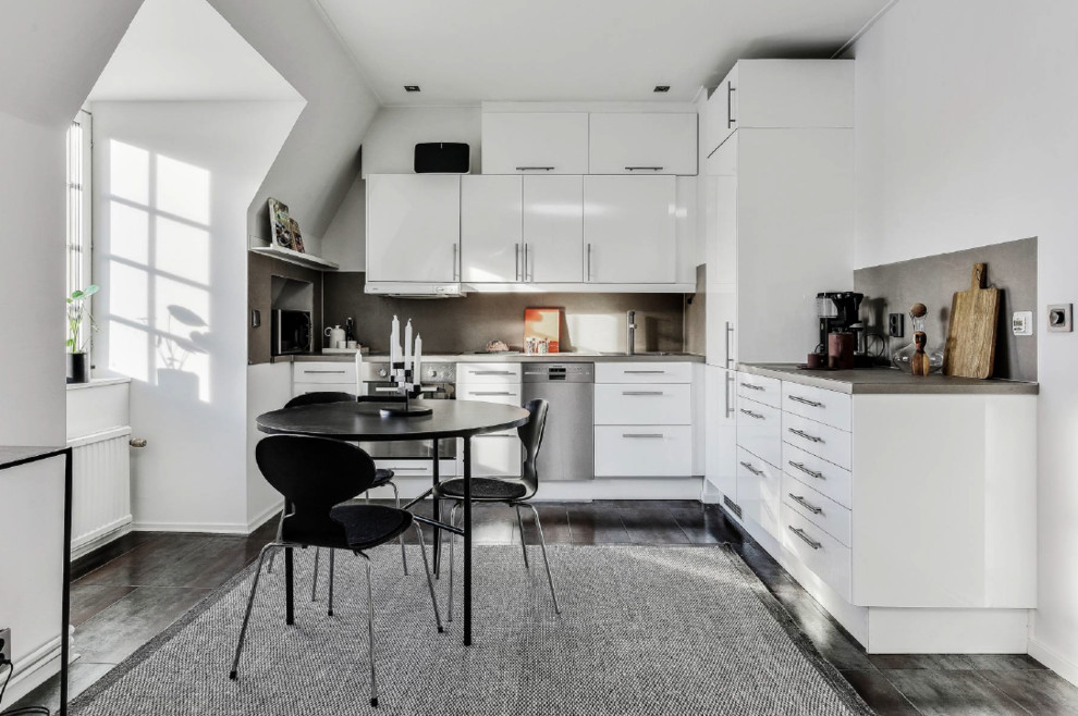 Inspiration för minimalistiska grått kök, med en nedsänkt diskho, släta luckor, vita skåp, grått stänkskydd, rostfria vitvaror och grått golv