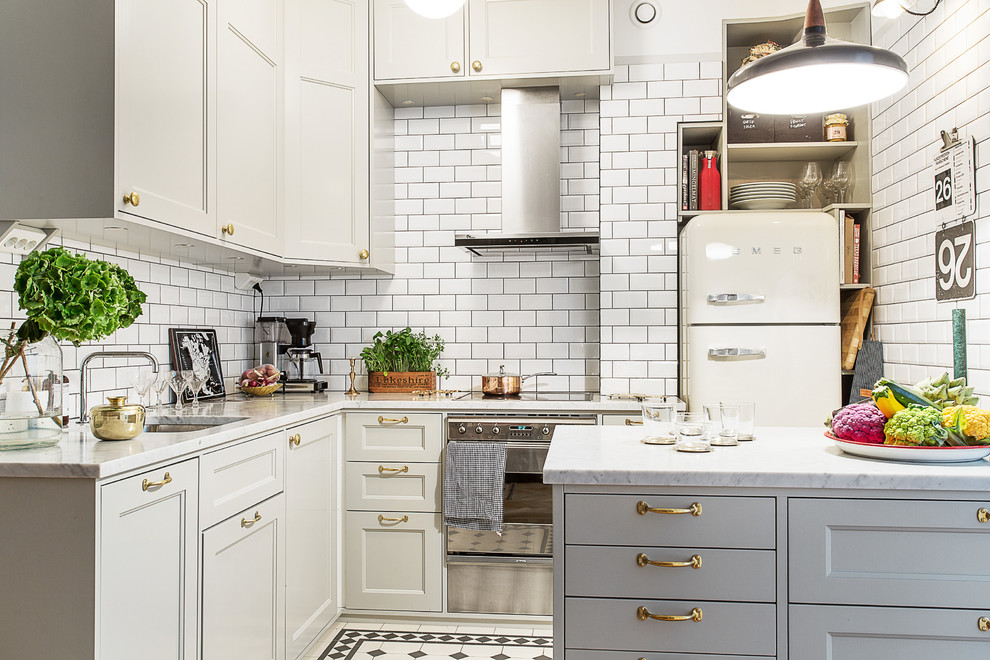 Mid-sized elegant l-shaped ceramic tile kitchen photo in Stockholm with an undermount sink, recessed-panel cabinets, marble countertops, white backsplash, subway tile backsplash, a peninsula, gray cabinets and white appliances
