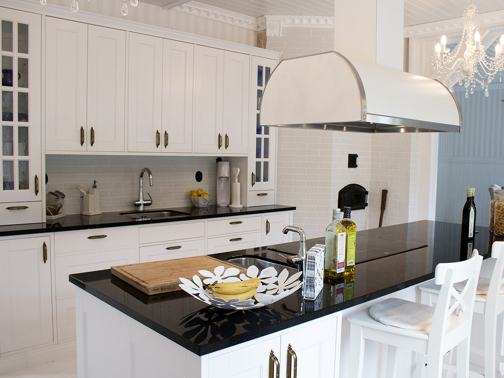 Idéer för stora svart kök, med en enkel diskho, luckor med profilerade fronter, vita skåp, granitbänkskiva, vitt stänkskydd, stänkskydd i keramik, vita vitvaror, ljust trägolv och en köksö