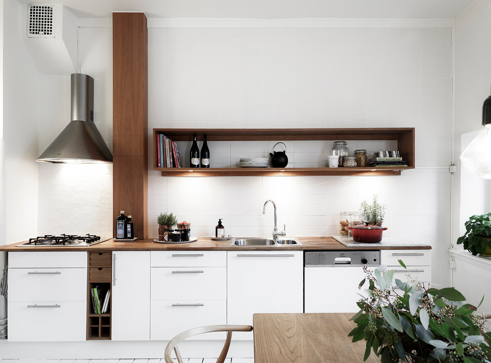 Medium sized scandinavian single-wall kitchen/diner in Gothenburg with a double-bowl sink, flat-panel cabinets, white cabinets, wood worktops, painted wood flooring and no island.