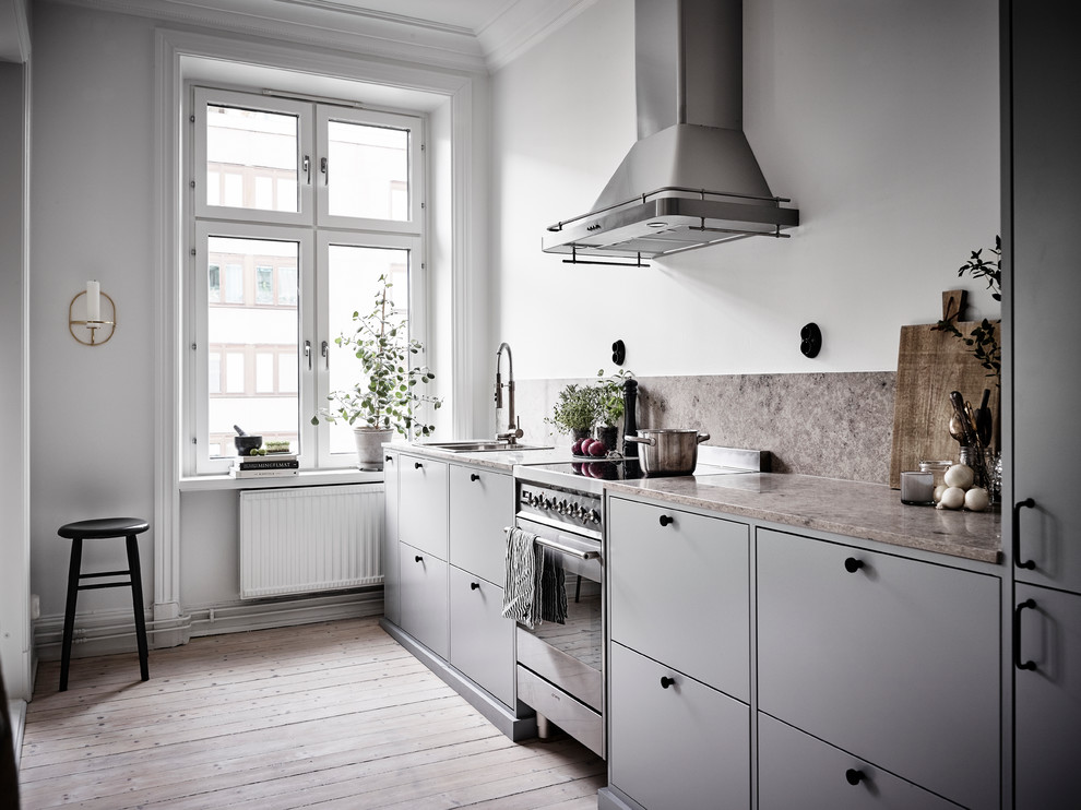 Idéer för att renovera ett mellanstort nordiskt linjärt kök och matrum, med en dubbel diskho, släta luckor, grå skåp, rostfria vitvaror och ljust trägolv