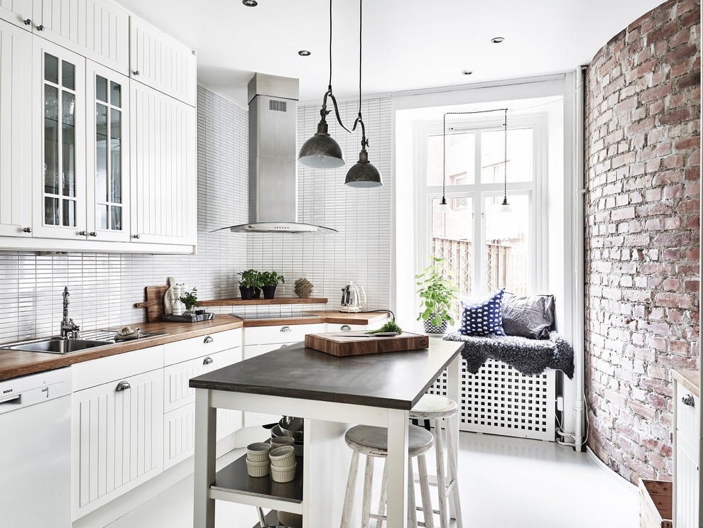 Inspiration för avskilda, stora skandinaviska l-kök, med en nedsänkt diskho, luckor med upphöjd panel, vita skåp, träbänkskiva, vitt stänkskydd och en köksö