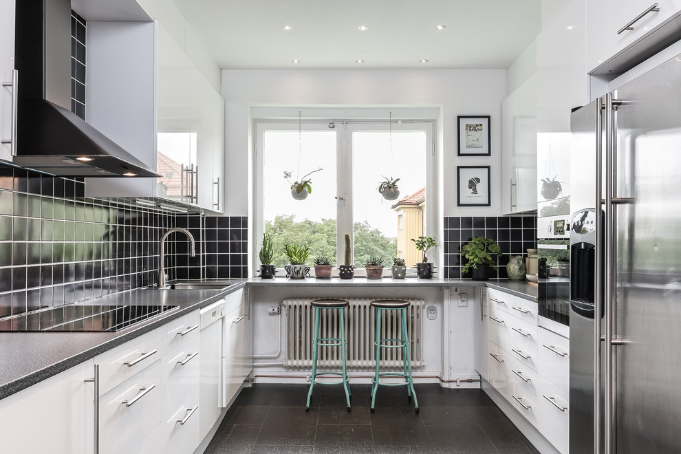 Medium sized eclectic u-shaped kitchen in Malmo with flat-panel cabinets, white cabinets, laminate countertops, black splashback, a single-bowl sink, stainless steel appliances, grey floors and grey worktops.