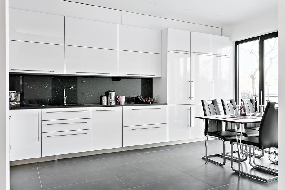 Esempio di una cucina moderna di medie dimensioni con lavello a doppia vasca, ante lisce, ante bianche, paraspruzzi nero, elettrodomestici da incasso, nessuna isola, pavimento grigio e top nero