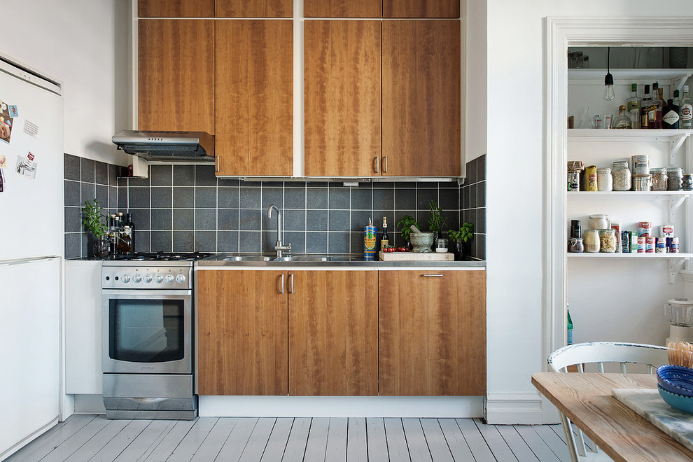 Idéer för att renovera ett stort minimalistiskt linjärt kök med öppen planlösning, med en dubbel diskho, släta luckor, skåp i mellenmörkt trä, bänkskiva i rostfritt stål, grått stänkskydd, stänkskydd i keramik, målat trägolv och rostfria vitvaror