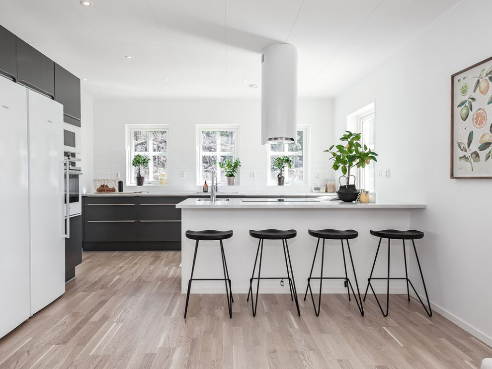 Immagine di una cucina ad U minimal di medie dimensioni con lavello sottopiano, ante lisce, penisola, pavimento beige e top bianco