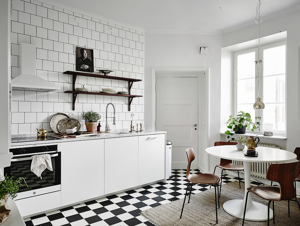 Идея дизайна: прямая кухня среднего размера в скандинавском стиле с плоскими фасадами, белыми фасадами, белым фартуком, одинарной мойкой, мраморной столешницей, белой техникой и полом из керамической плитки без острова