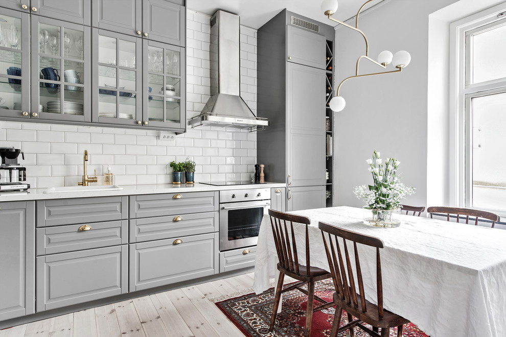 Idéer för mellanstora skandinaviska linjära kök och matrum, med grå skåp, vitt stänkskydd, ljust trägolv, beiget golv, en nedsänkt diskho, luckor med glaspanel och stänkskydd i tunnelbanekakel