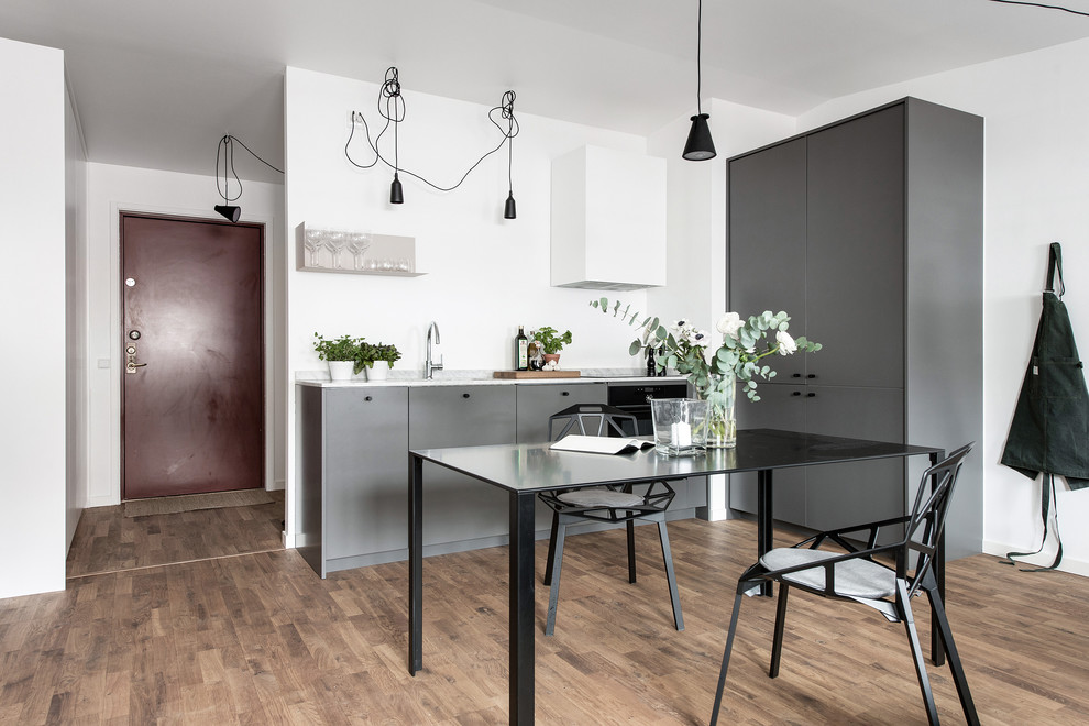 Eat-in kitchen - small scandinavian l-shaped medium tone wood floor and brown floor eat-in kitchen idea in Gothenburg with flat-panel cabinets, gray cabinets and no island