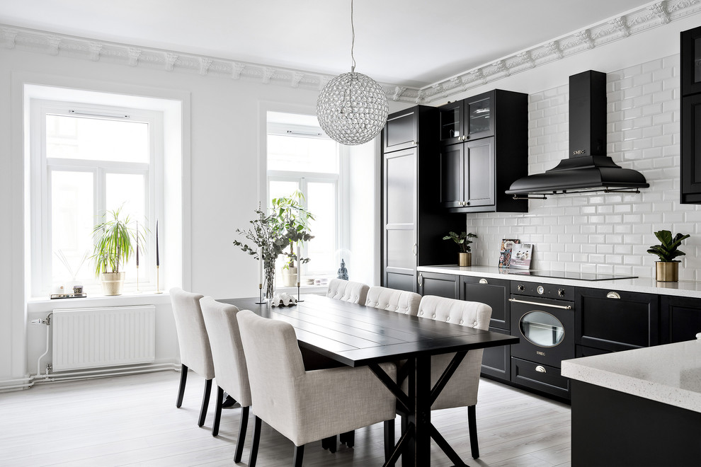 Inredning av ett minimalistiskt stort grå grått kök, med svarta skåp, integrerade vitvaror, skåp i shakerstil, vitt stänkskydd, stänkskydd i tunnelbanekakel och beiget golv