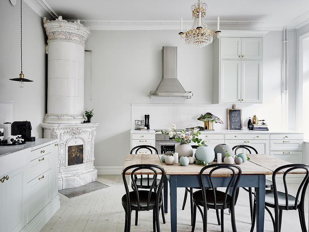 На фото: большая прямая кухня в викторианском стиле с фасадами с утопленной филенкой, серыми фасадами, белым фартуком, техникой из нержавеющей стали, деревянным полом и мраморной столешницей с