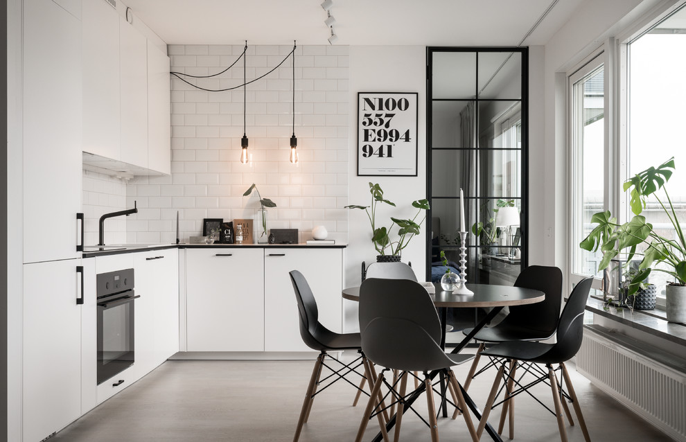 Mittelgroße Nordische Küche ohne Insel in L-Form mit flächenbündigen Schrankfronten, weißen Schränken, Elektrogeräten mit Frontblende, Betonboden und weißem Boden in Stockholm