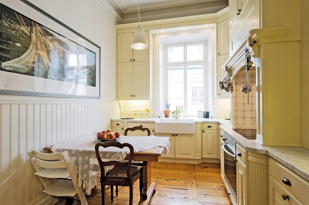 Inspiration för stora klassiska kök, med en nedsänkt diskho, beige skåp, marmorbänkskiva, rostfria vitvaror, mellanmörkt trägolv och luckor med upphöjd panel