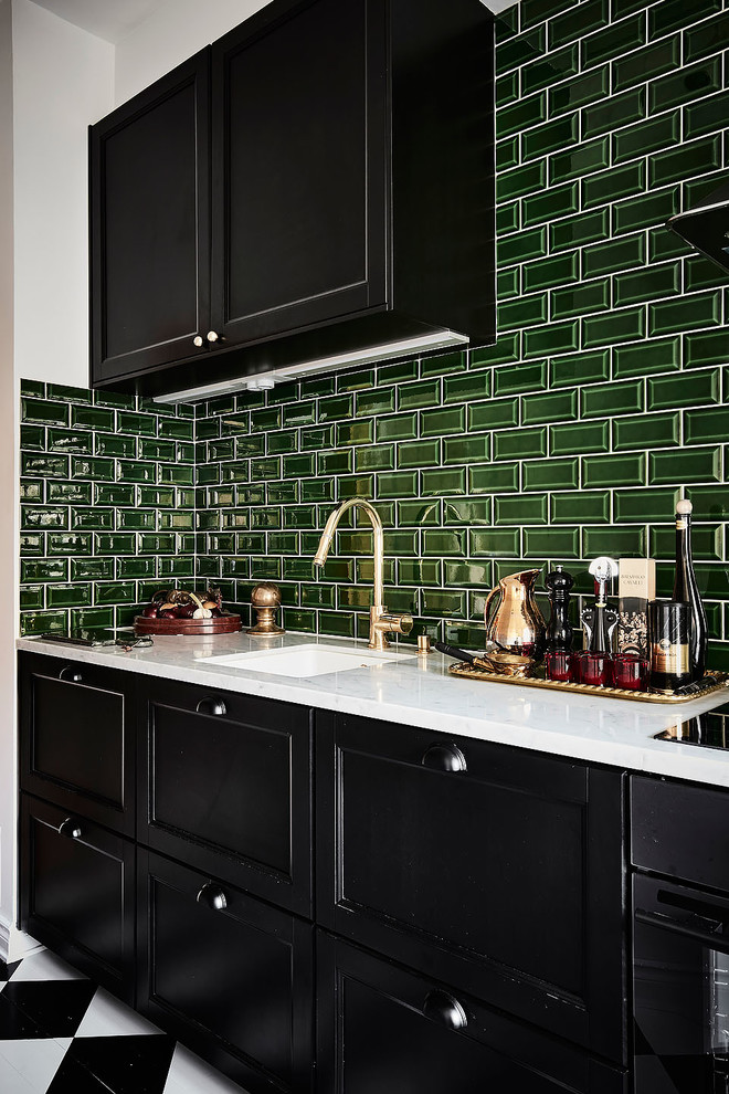 Inredning av ett modernt avskilt, litet linjärt kök, med en enkel diskho, svarta skåp, marmorbänkskiva, grönt stänkskydd, rostfria vitvaror och flerfärgat golv