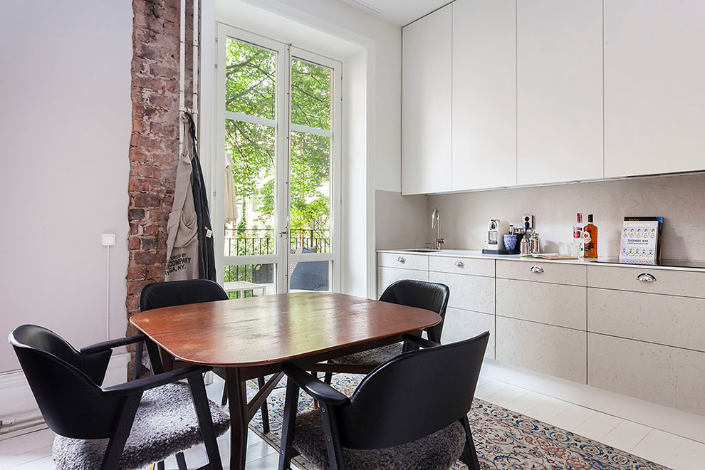 Photo of a small contemporary l-shaped open plan kitchen in Stockholm with a submerged sink, flat-panel cabinets, white cabinets, grey splashback, painted wood flooring and no island.