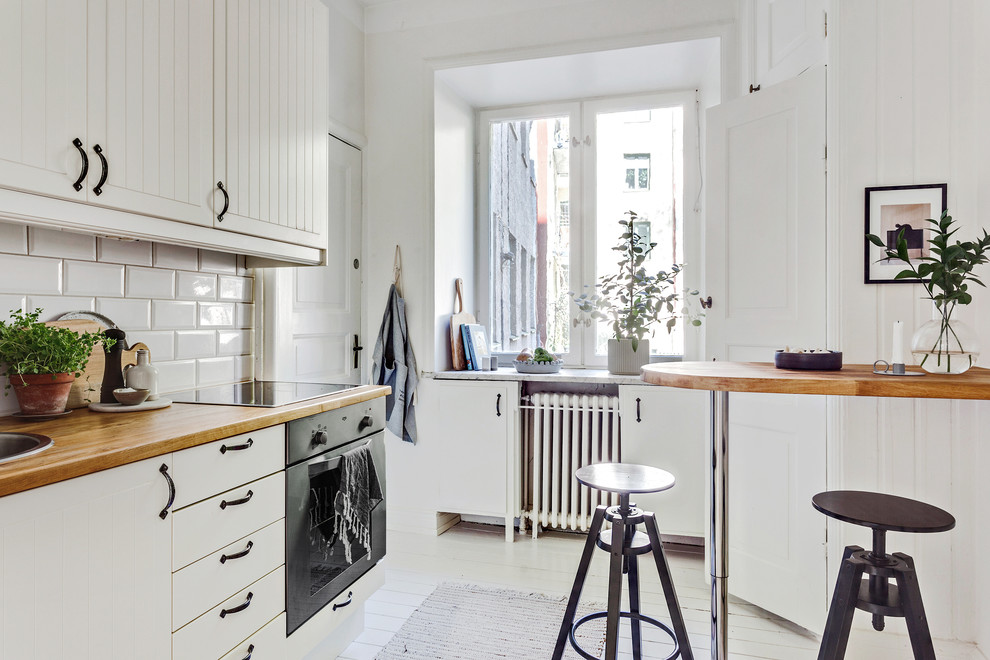 Aménagement d'une cuisine scandinave avec un plan de travail en bois et un plan de travail beige.
