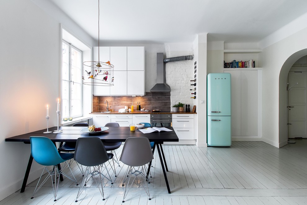 Eat-in kitchen - large scandinavian single-wall painted wood floor eat-in kitchen idea in Stockholm with flat-panel cabinets, white cabinets, wood countertops, colored appliances, no island and a drop-in sink