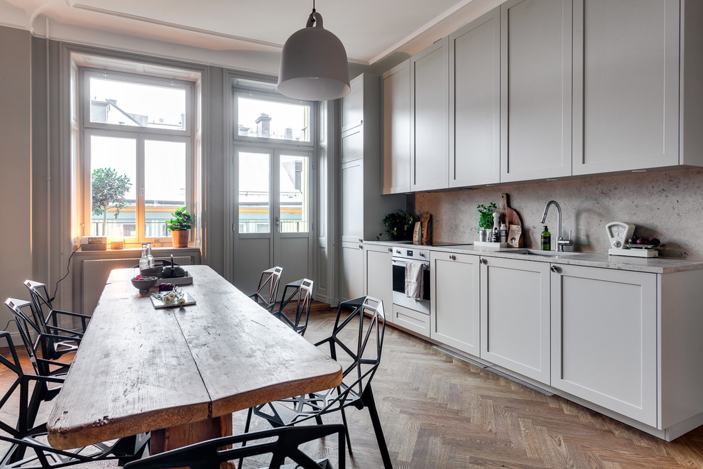 Idéer för mellanstora skandinaviska linjära kök, med en enkel diskho, luckor med infälld panel, grå skåp, marmorbänkskiva och mellanmörkt trägolv