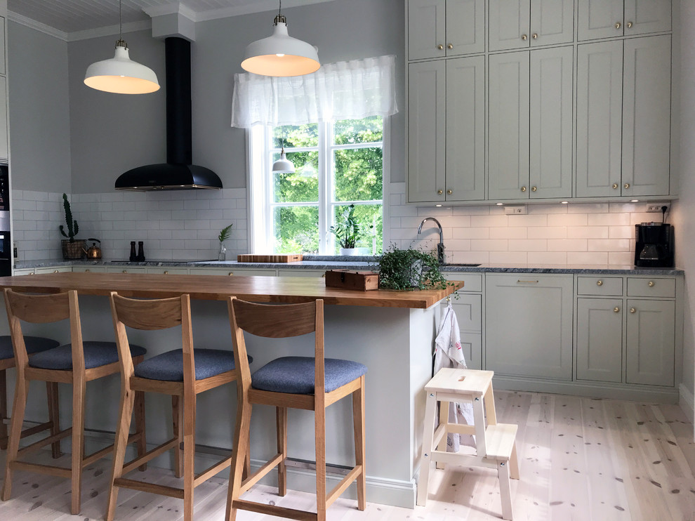 Kitchen - huge cottage l-shaped kitchen idea in Other with a single-bowl sink, shaker cabinets, green cabinets, granite countertops, white backsplash, porcelain backsplash, stainless steel appliances, an island and gray countertops