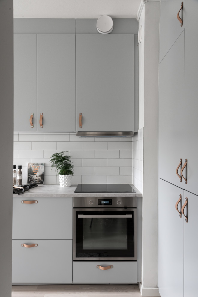 Foto de cocina escandinava pequeña cerrada con fregadero de un seno, puertas de armario grises, encimera de laminado y encimeras grises