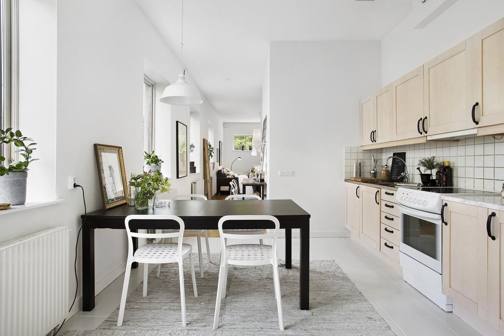 Inspiration for a medium sized scandinavian single-wall kitchen/diner in Gothenburg with light wood cabinets, white splashback, white appliances, no island, marble worktops, ceramic flooring and shaker cabinets.