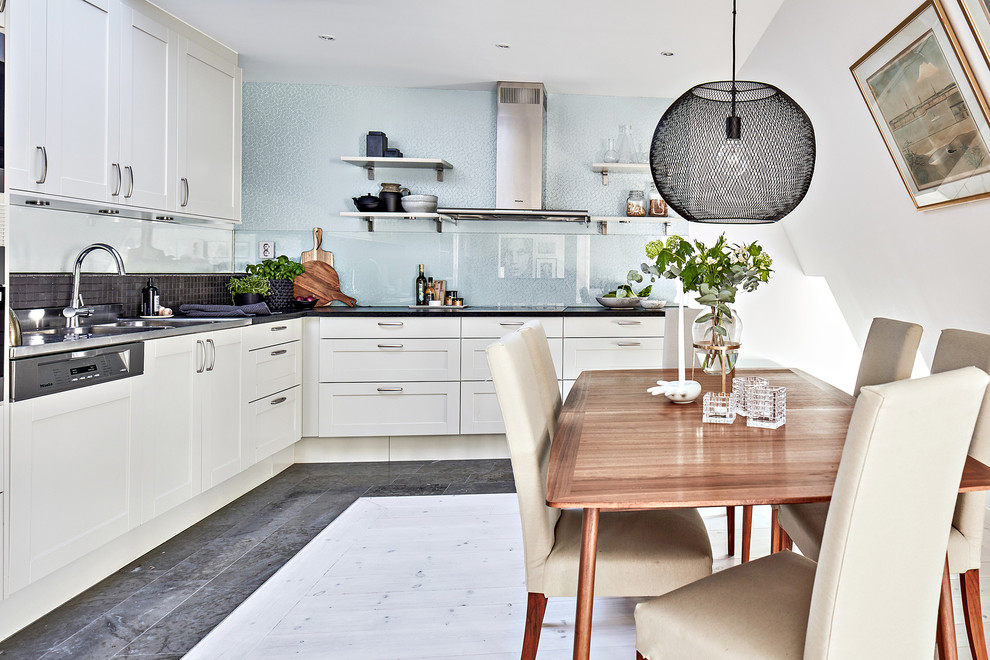 Inspiration for a medium sized scandi kitchen/diner in Gothenburg with recessed-panel cabinets, white cabinets, glass sheet splashback, integrated appliances and no island.