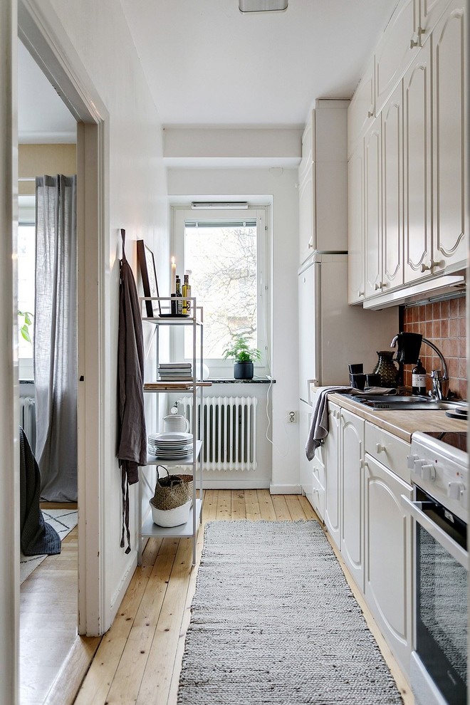 Inspiration for a small scandinavian single-wall enclosed kitchen remodel in Stockholm with terra-cotta backsplash and no island