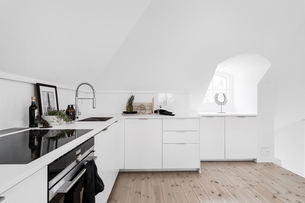 Idéer för ett avskilt, mellanstort nordiskt vit l-kök, med släta luckor, vita skåp, en nedsänkt diskho, ljust trägolv och beiget golv