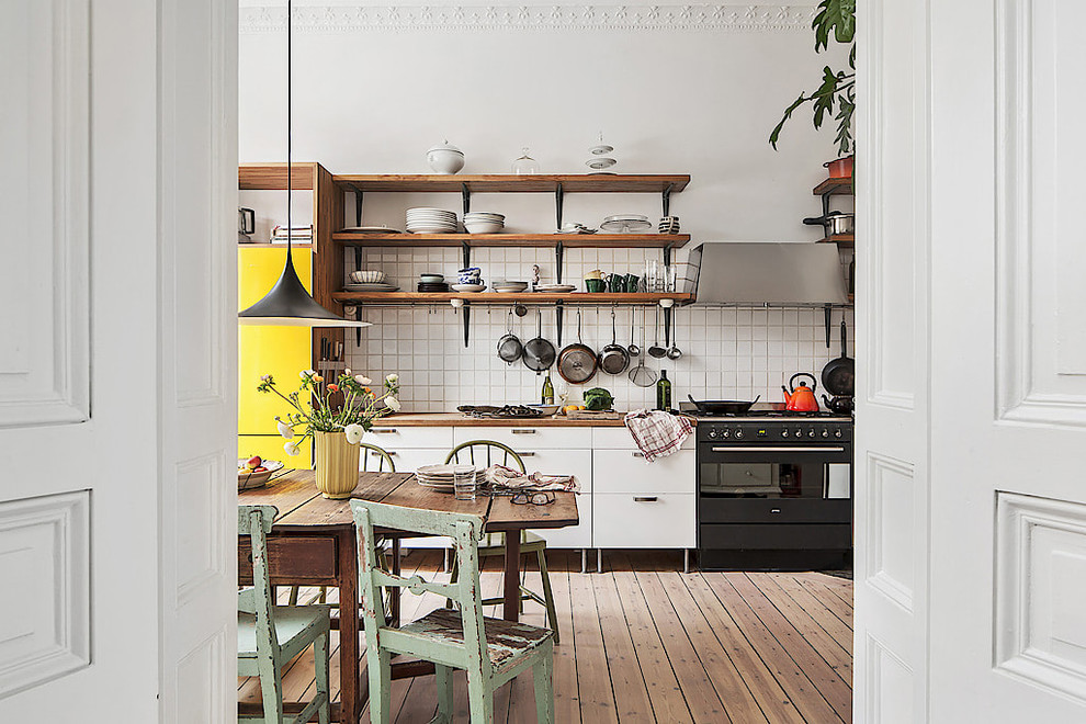 Mid-sized danish single-wall medium tone wood floor kitchen photo in Stockholm with open cabinets, dark wood cabinets, wood countertops, white backsplash, ceramic backsplash, paneled appliances and no island