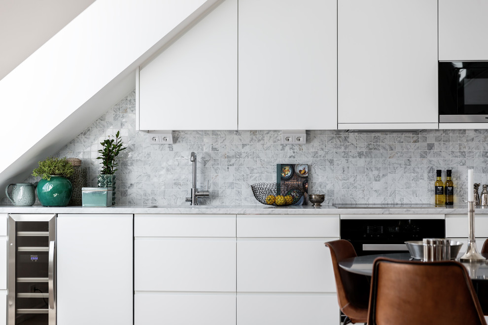 Kitchen - scandinavian kitchen idea in Stockholm with an undermount sink, flat-panel cabinets, white cabinets, gray backsplash and stainless steel appliances