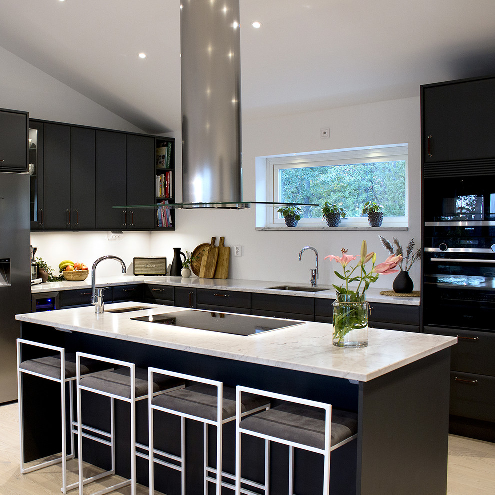 This is an example of a medium sized scandinavian l-shaped kitchen in Other with a single-bowl sink, flat-panel cabinets, black cabinets, engineered stone countertops, white splashback, black appliances, laminate floors, an island, white worktops and beige floors.