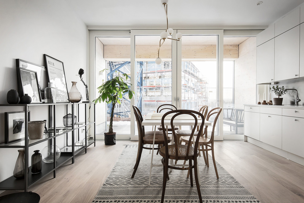 Foto de cocina escandinava sin isla con armarios con paneles lisos, puertas de armario grises, encimera de acero inoxidable y suelo de madera en tonos medios