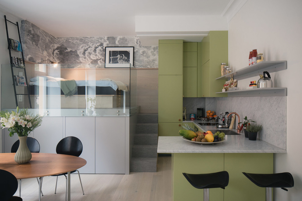 Foto på ett litet minimalistiskt grå kök, med gröna skåp, släta luckor, marmorbänkskiva, grått stänkskydd, stänkskydd i marmor, integrerade vitvaror och en halv köksö